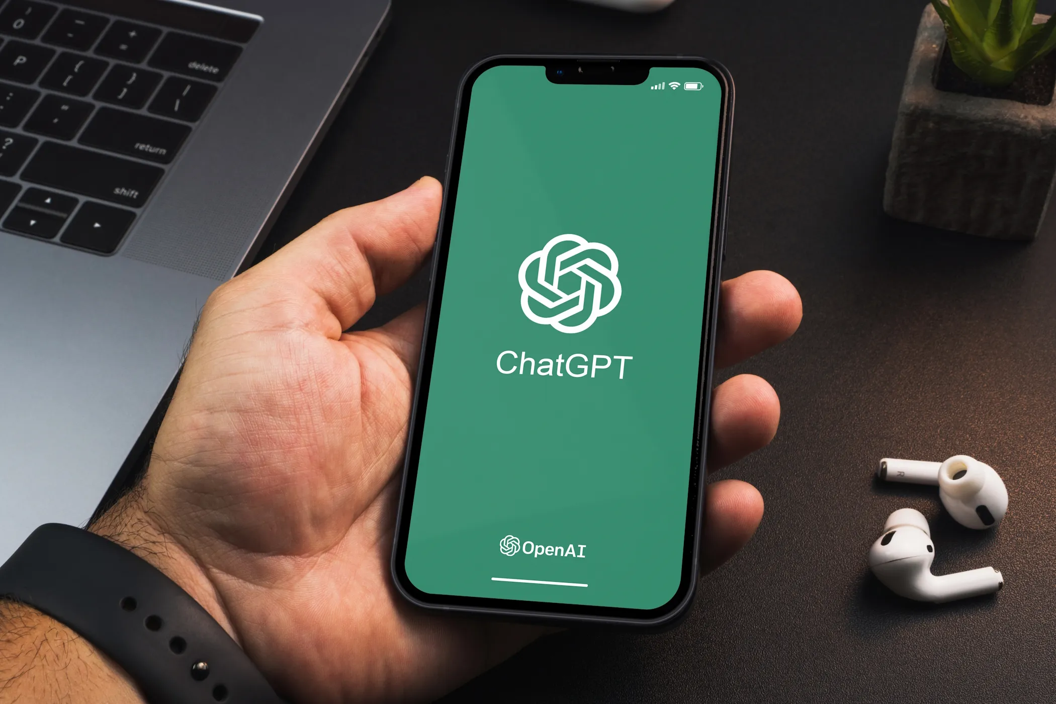ChatGPT running on an iPhone with a MacBook Pro and AirPods in the background