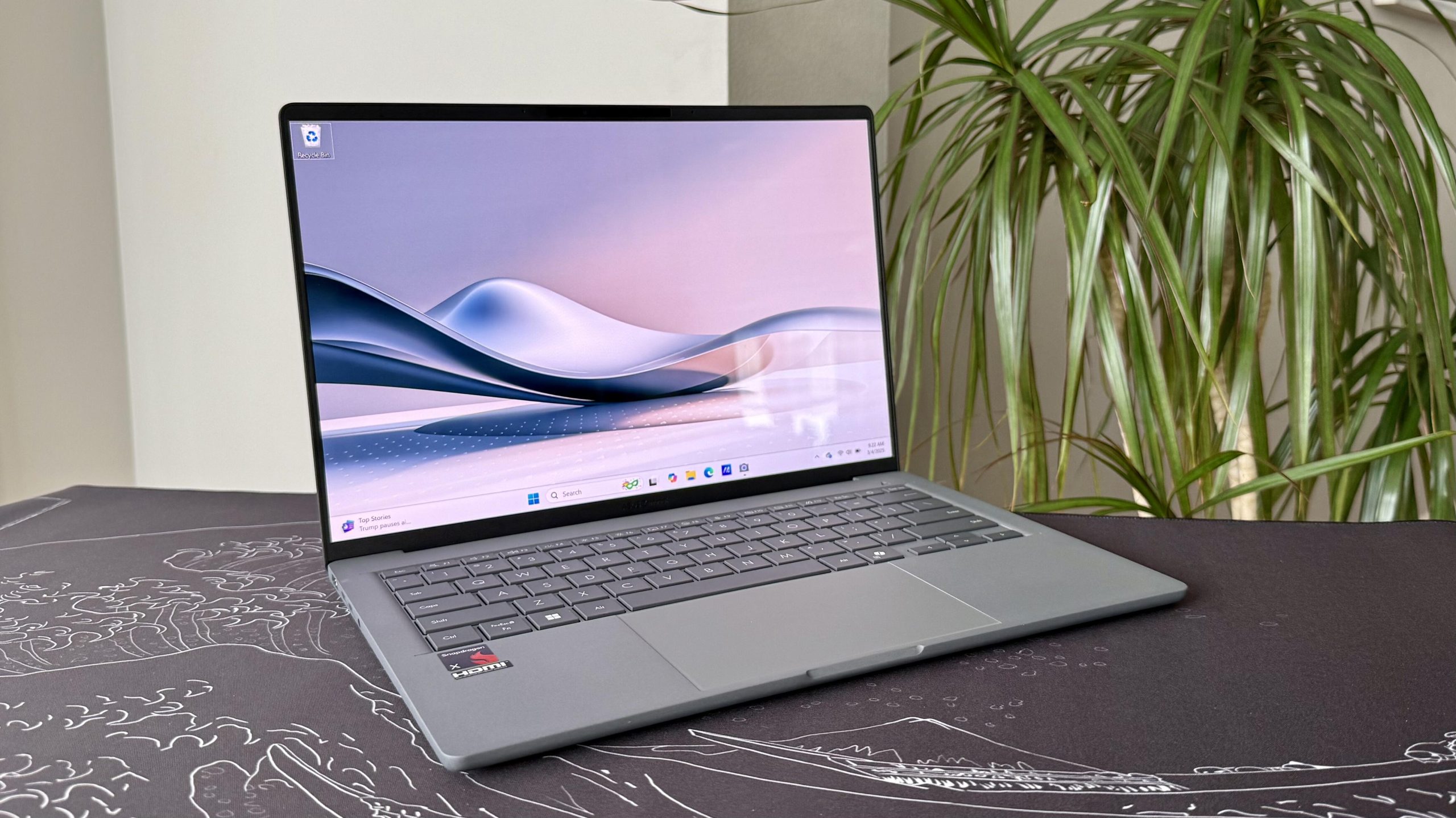 Asus Zenbook A14 Copilot Plus PC next to a house plant