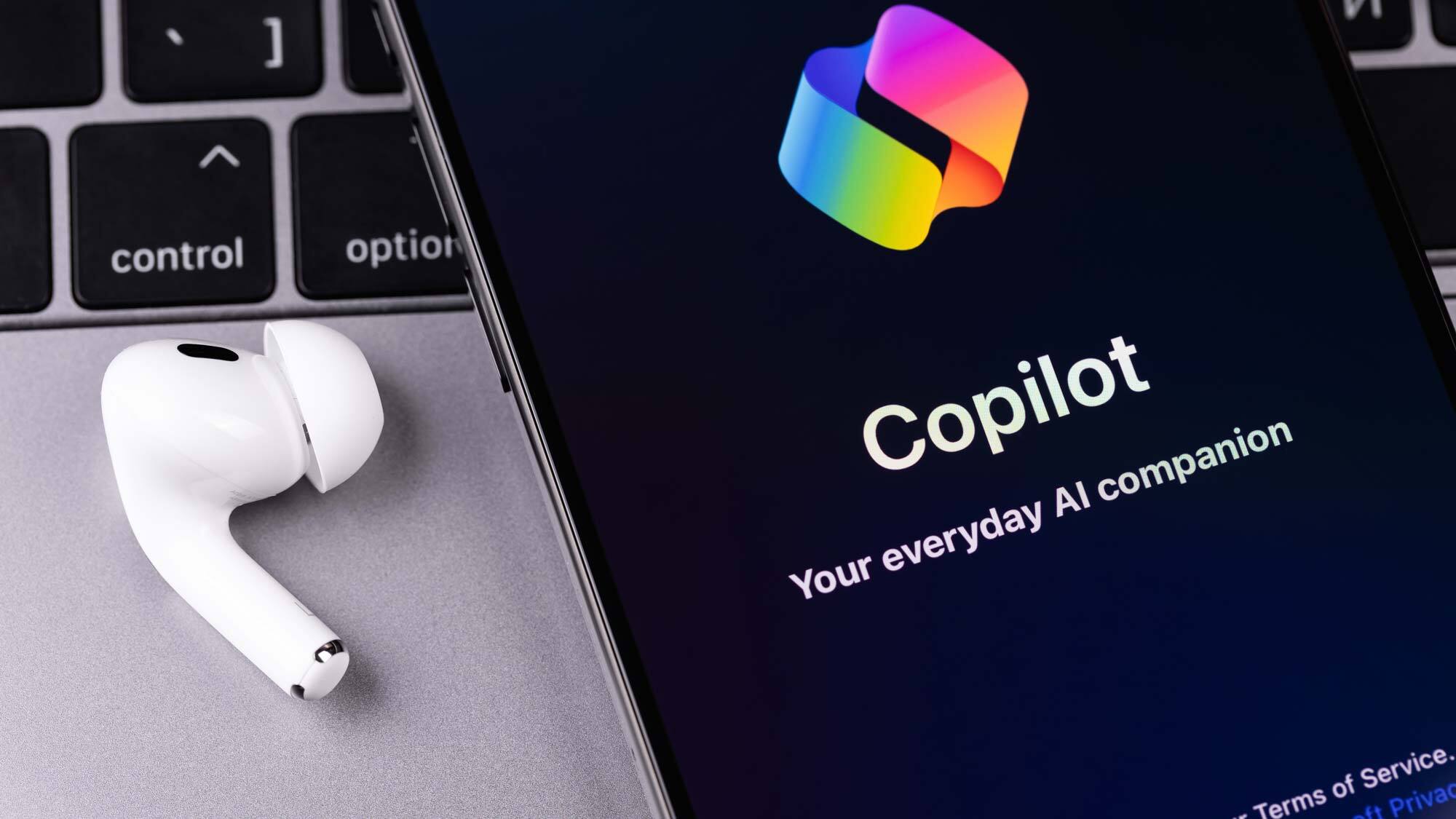 Copilot على هاتف مع سماعات أذن على مكتب
