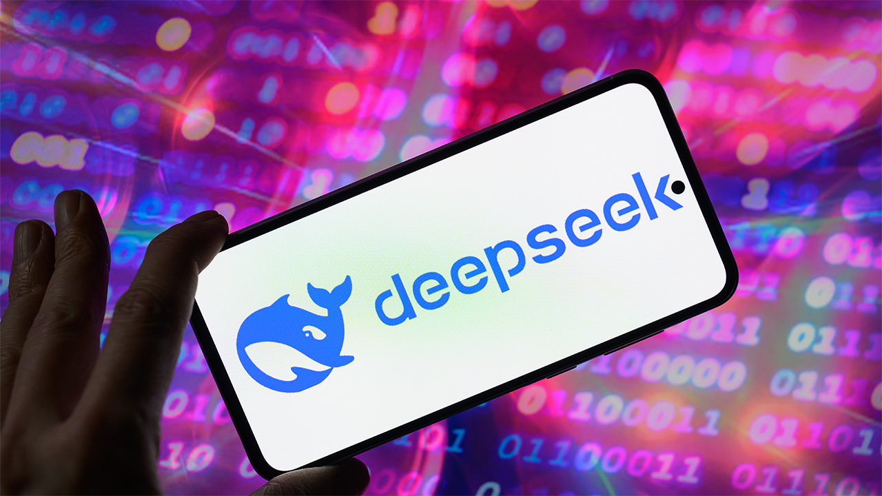 شعار DeepSeek على هاتف ذكي أمام بيانات الكمبيوتر