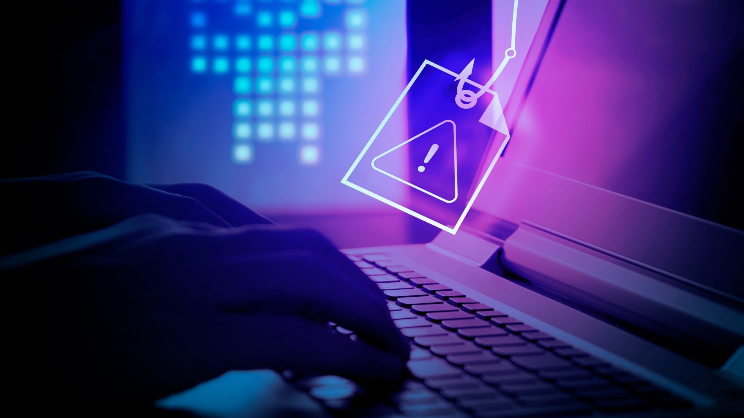 شخص يكتب على جهاز كمبيوتر بينما يستخدم المتسللون التصيد الاحتيالي لسرقة ملف من جهاز الكمبيوتر الخاص بهم