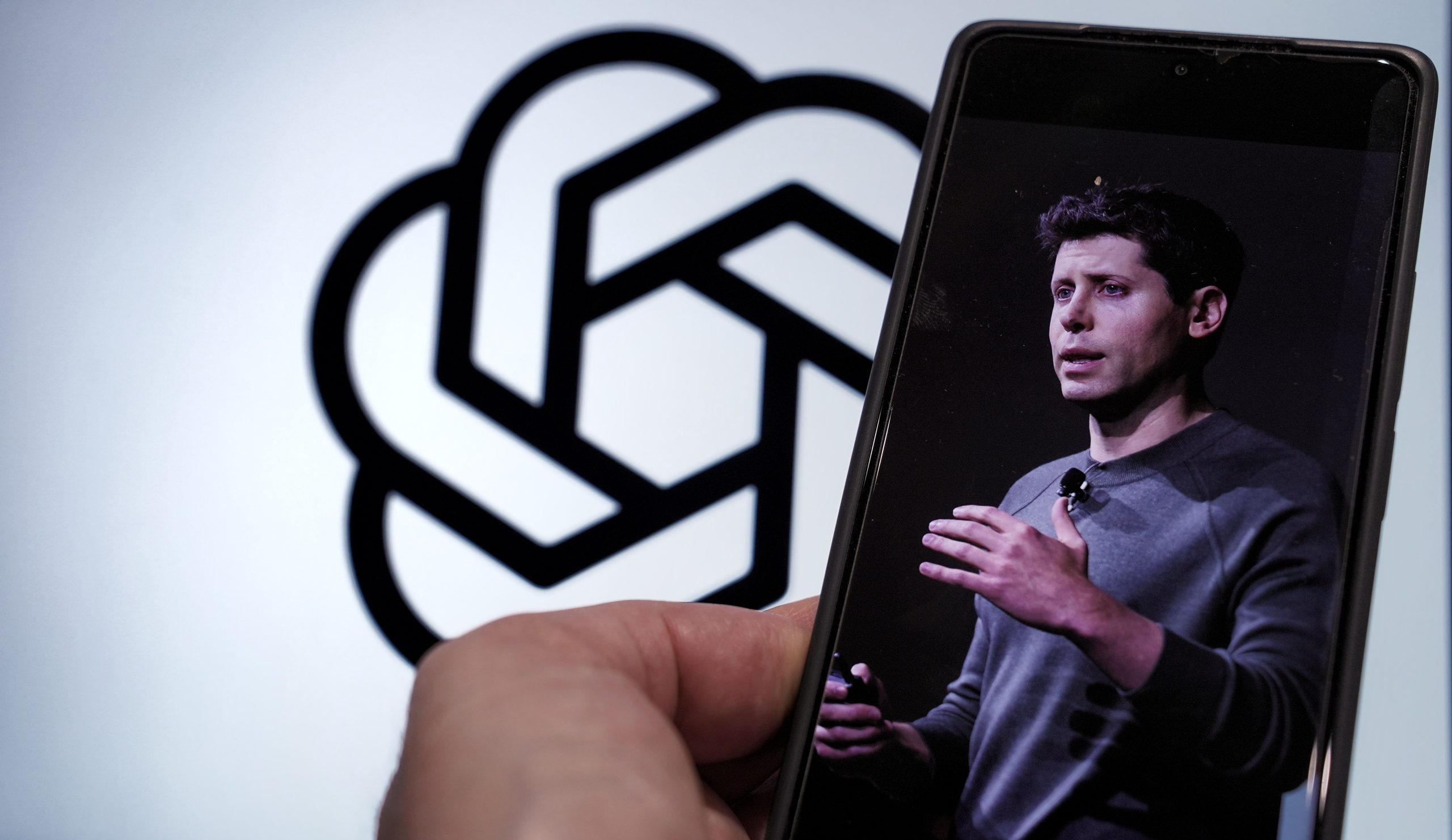 سام ألتمان يتحدث على الهاتف مع شعار ChatGPT