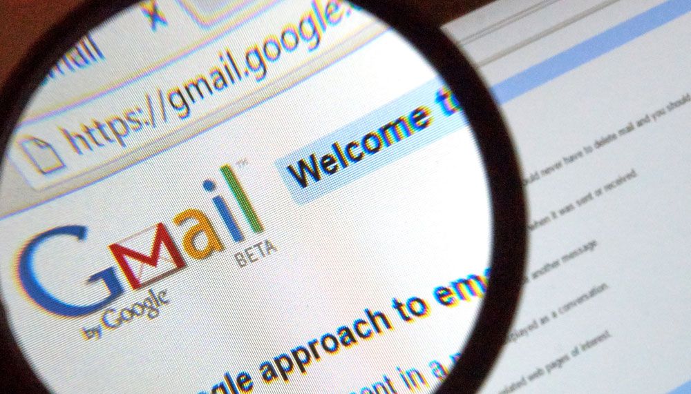 شعار Gmail على شاشة كمبيوتر تحت عدسة مكبرة.