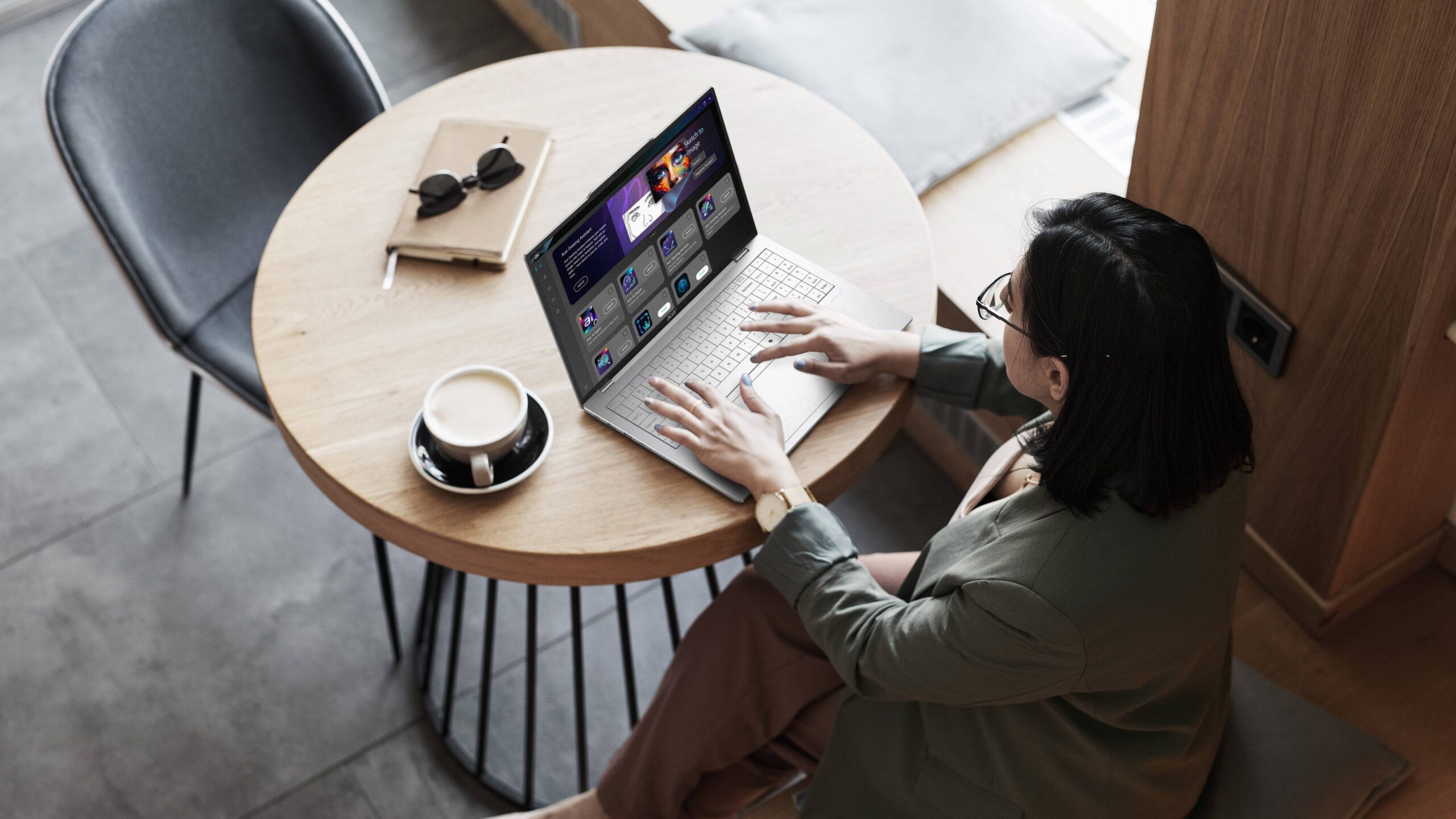 شخص يكتب على جهاز Acer Swift Air 16 على طاولة عليها قهوة ونظارات