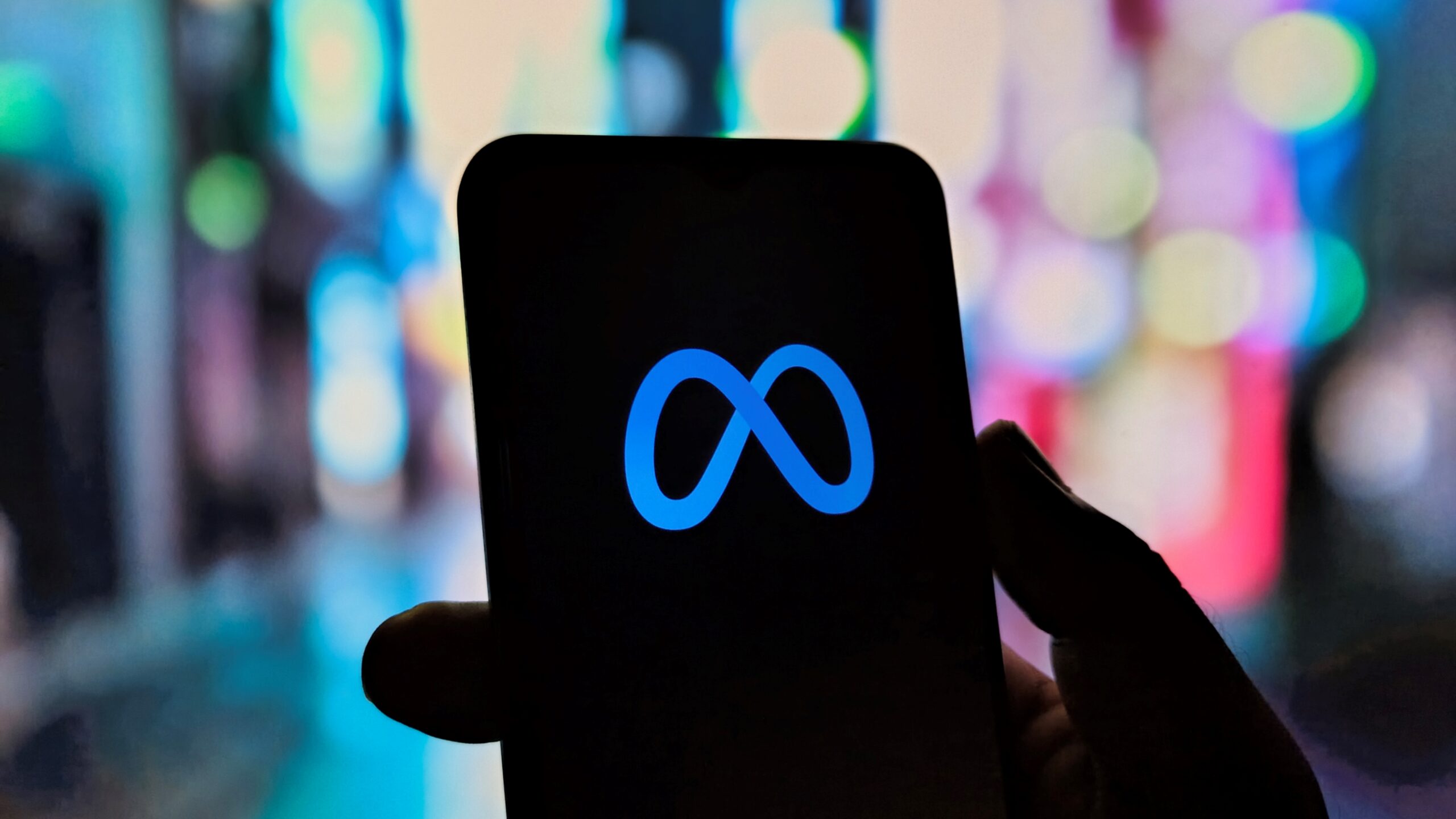 توضح هذه الصورة الاتصال الرقمي عبر جهاز محمول، مع تسليط الضوء على منصة Meta، مما يشير إلى التواصل الحديث والواقع الافتراضي والمشاركة في الميتافيرس.