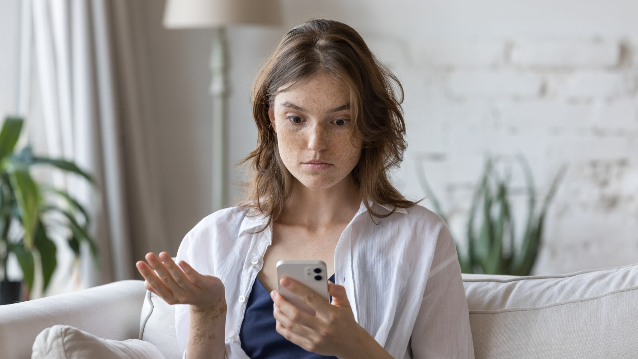 امرأة حائرة تنظر إلى هاتفها