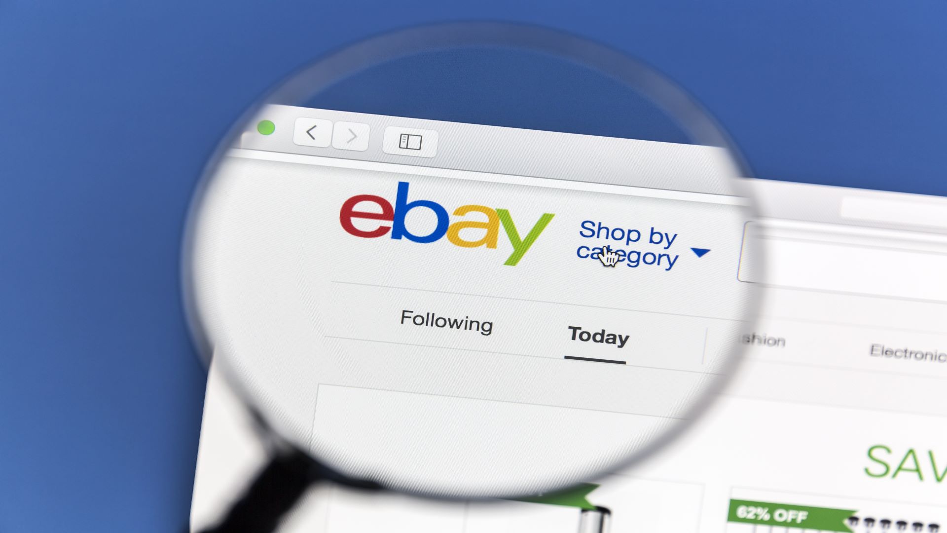 صورة تظهر الصفحة الرئيسية لموقع eBay مع عدسة مكبرة تسلط الضوء على الشعار