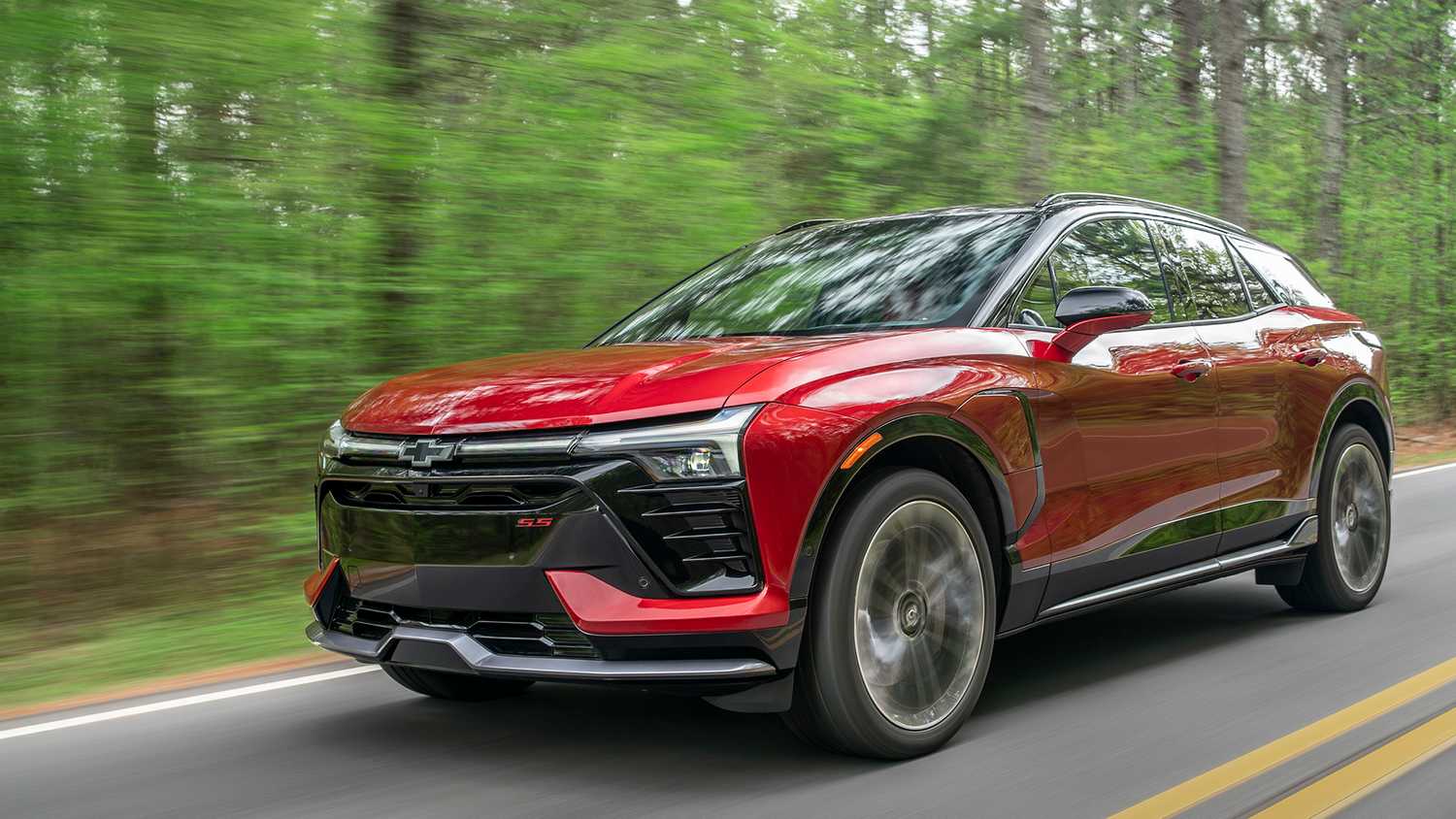 Red Cherolet Blazer SS driving through a wood.