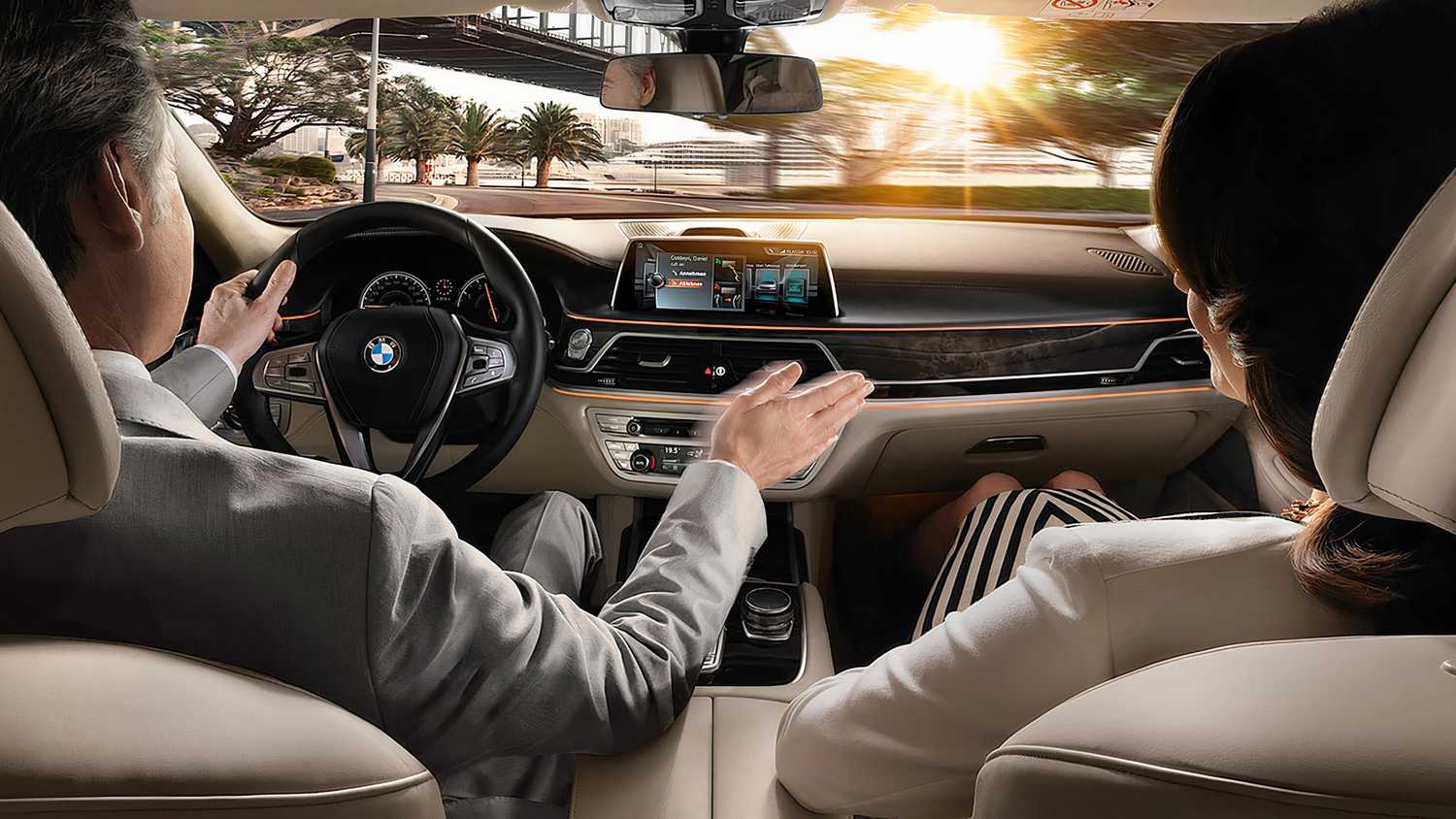 سائق سيارة BMW يستخدم نظام التحكم بالإيماءات المدمج في شاشة نظام المعلومات والترفيه.