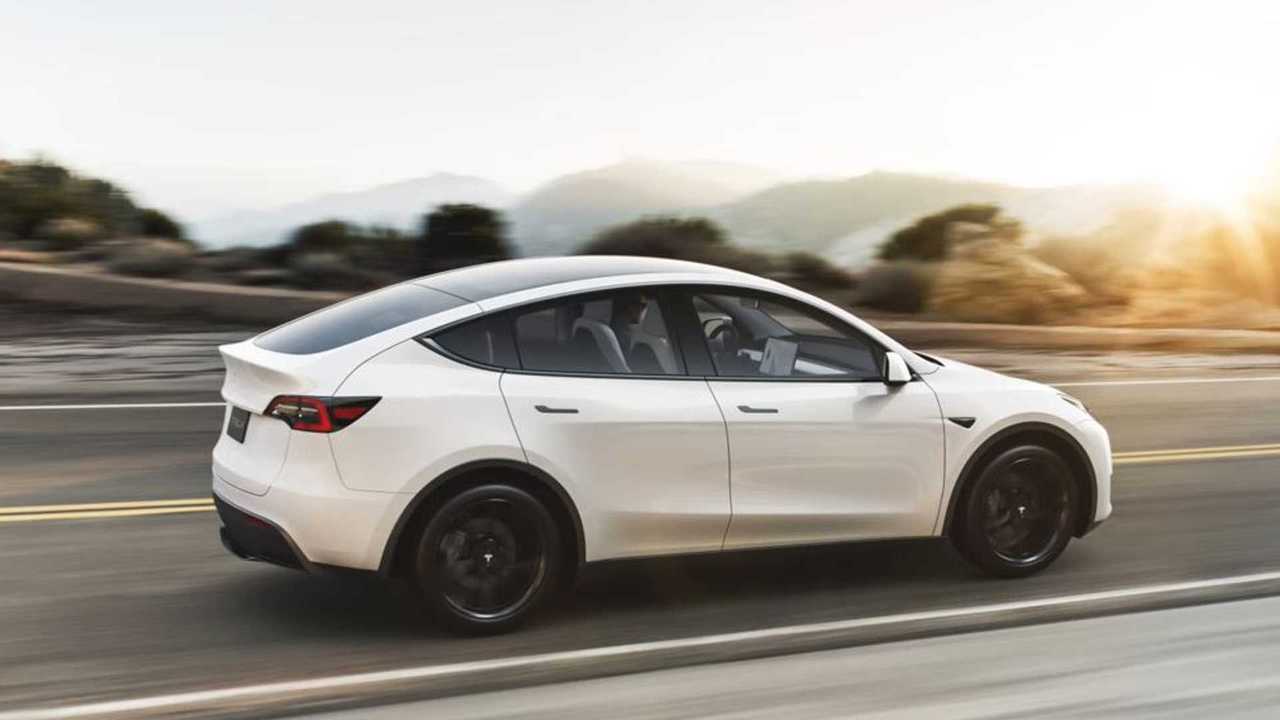 Tesla Model Y بيضاء أثناء القيادة