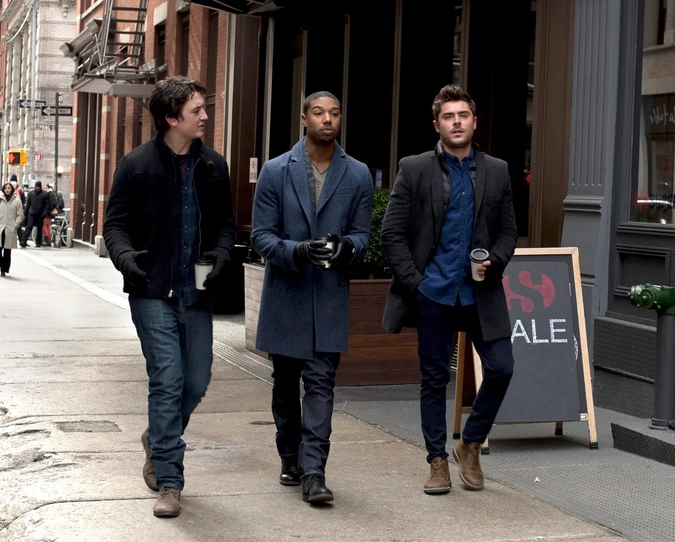 Three men walking down the street in the winter.