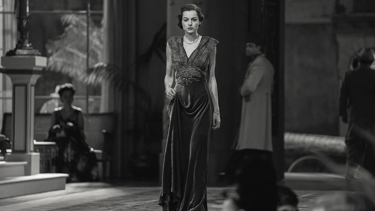 A black and white image of a woman in a fancy dress walking in the Reverie episode of Black Mirror.