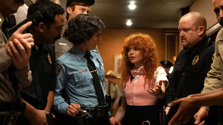 Charlie talking in a huddle with some police officers in Poker Face season 2.