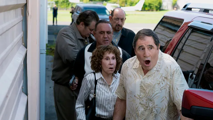 Several people huddled in a corner and looking shocked in Poker Face season 2.