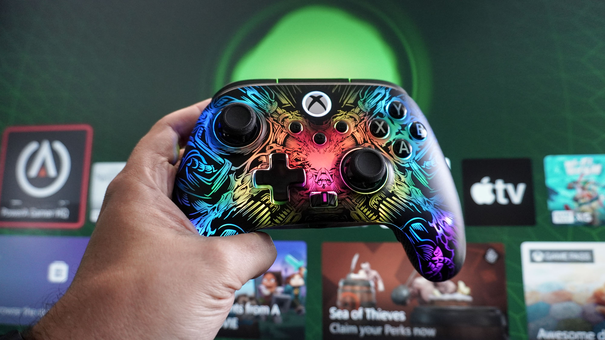 شخص يحمل وحدة التحكم اللاسلكية PowerA Fusion Pro أمام شاشة Xbox الرئيسية
