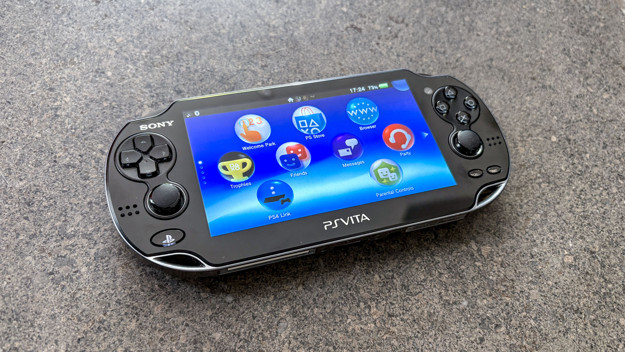 PS Vita على سطح مع قائمة الشاشة الرئيسية معروضة