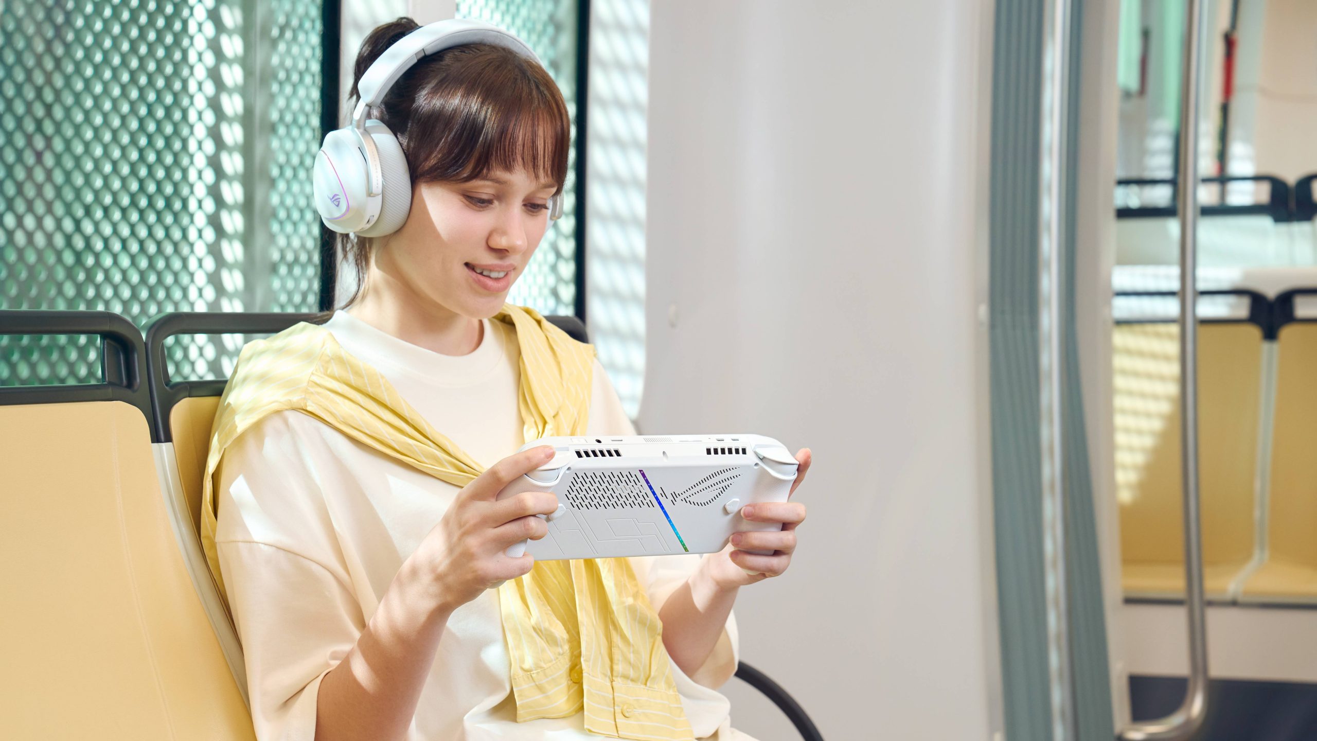 ROG Xbox Ally being play by person on public transport with headphones