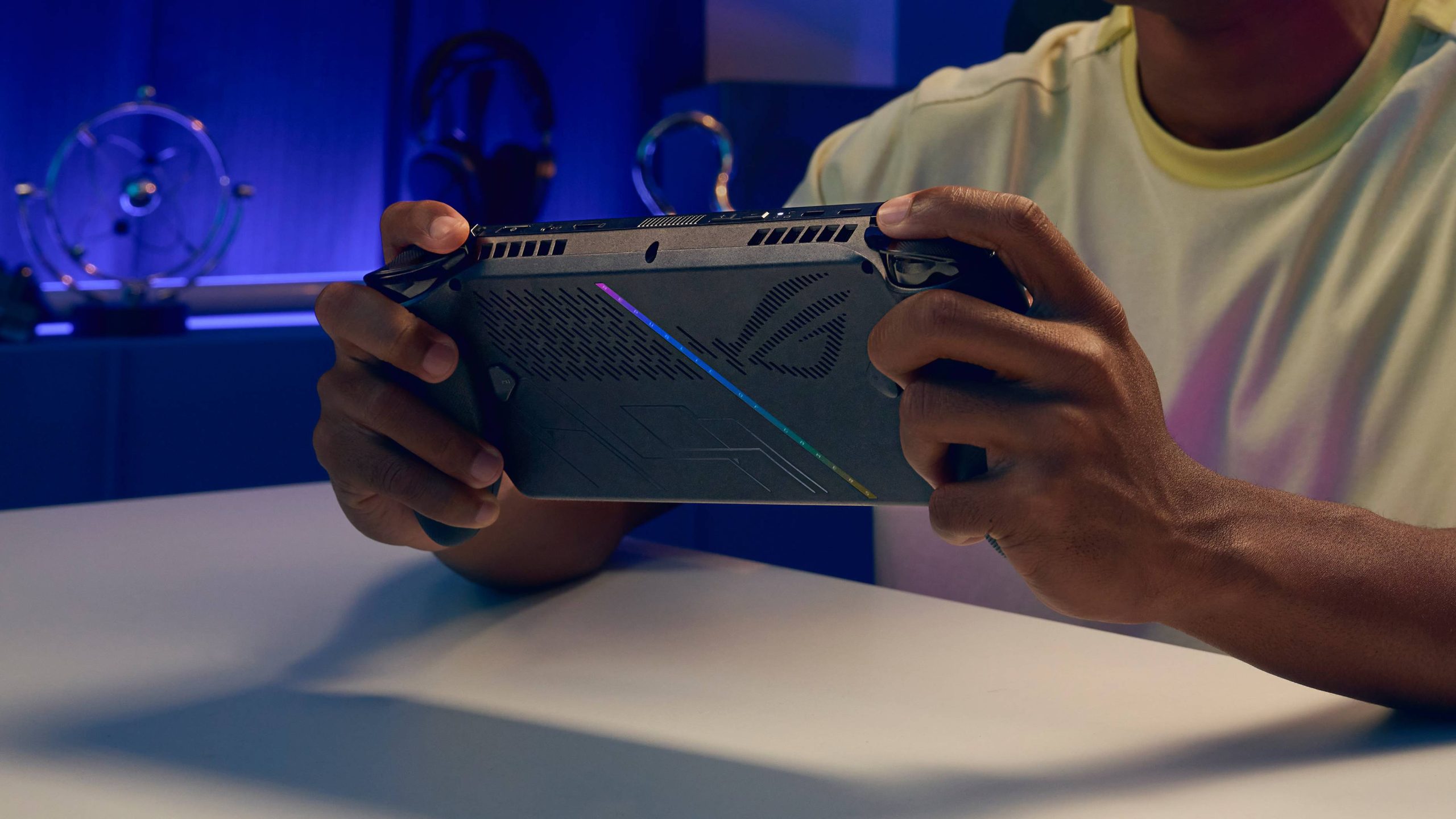 Rear shot of ROG Xbox Ally X being held in hands on desk