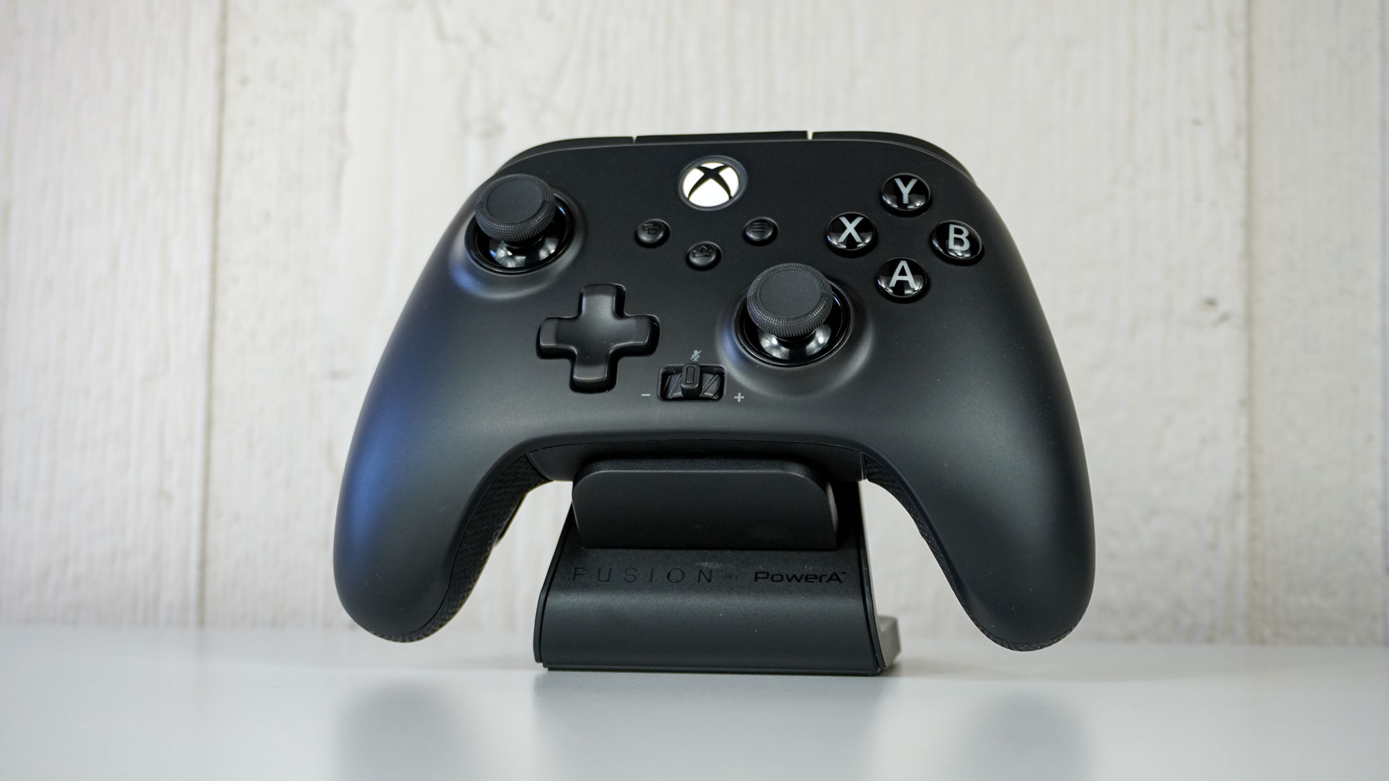 The PowerA Fusion Pro Wireless Controller on its included charging stand on a table