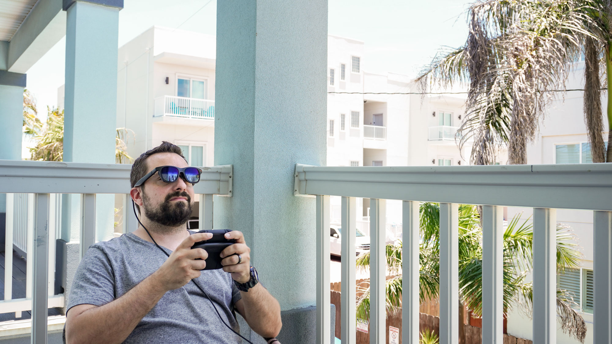 A person outside playing the Nintendo Switch 2 with AR glasses on thanks to the Viture Pro Mobile Dock