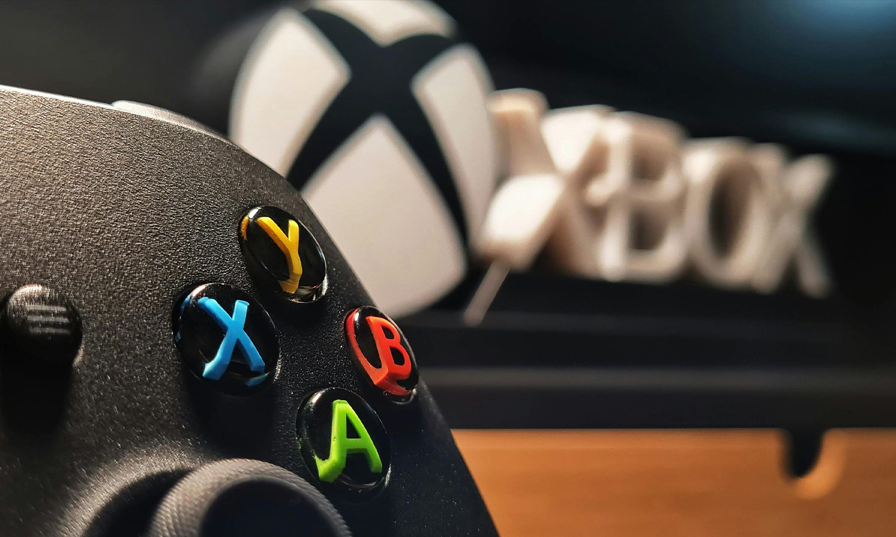 وحدة تحكم Xbox مع شعار Xbox في الخلفية