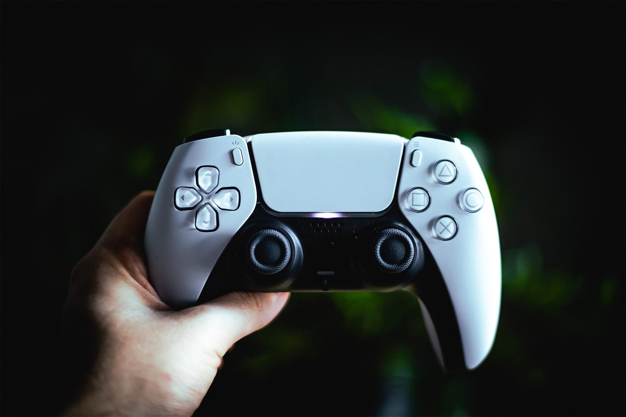 شخص يمسك بوحدة تحكم PS5.