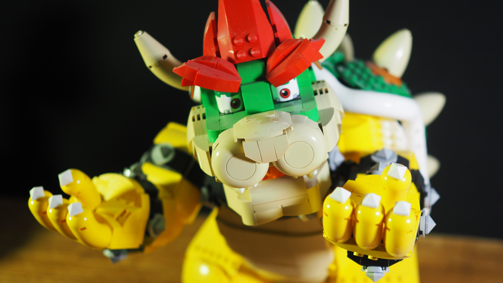 Lego The Mighty Bowser على طاولة خشبية ويداه في الهواء