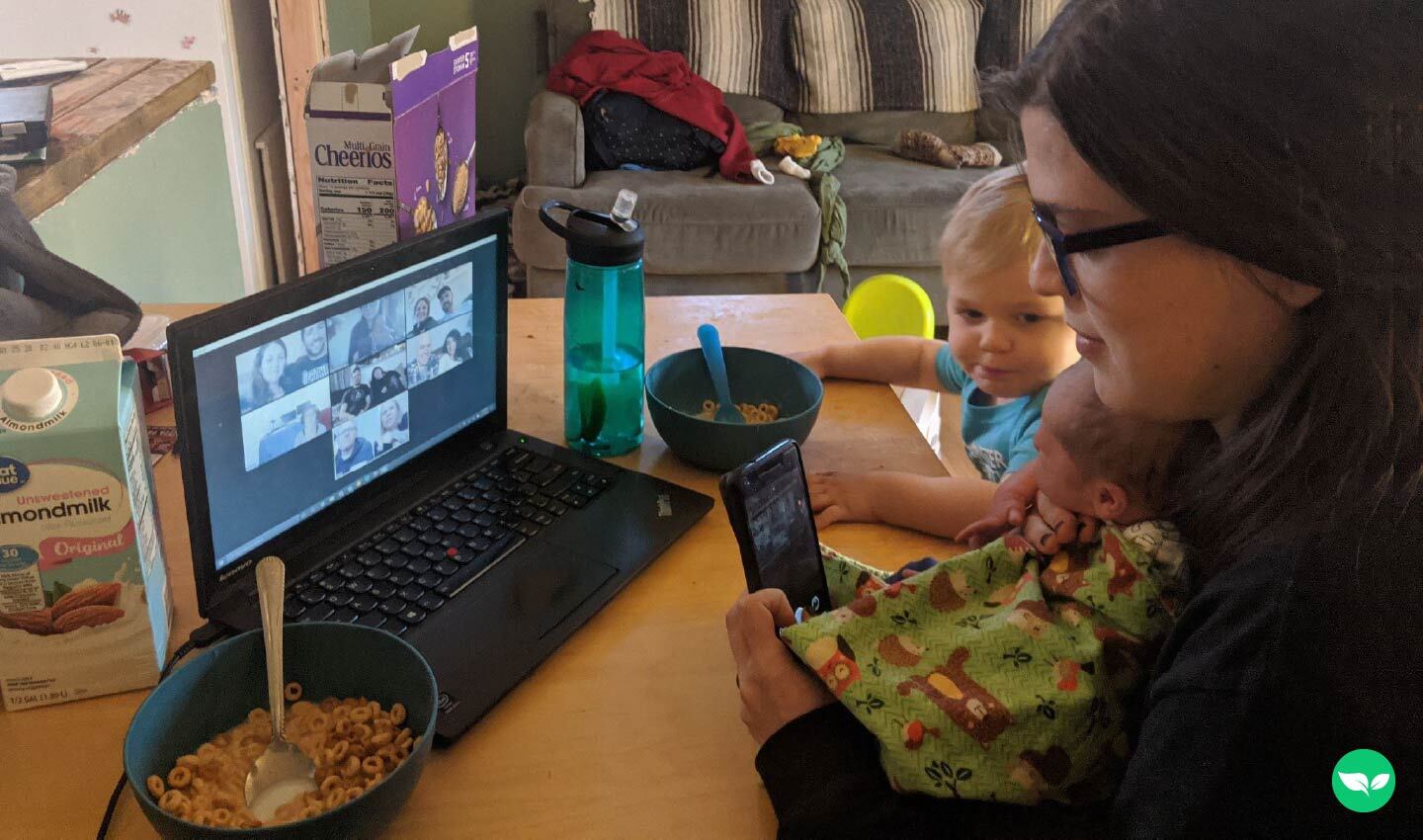Nicole Majelsen tiene in braccio i suoi due figli sul tavolo della cucina di casa durante una videochiamata su Zoom con la sua agenzia di assistenza virtuale.