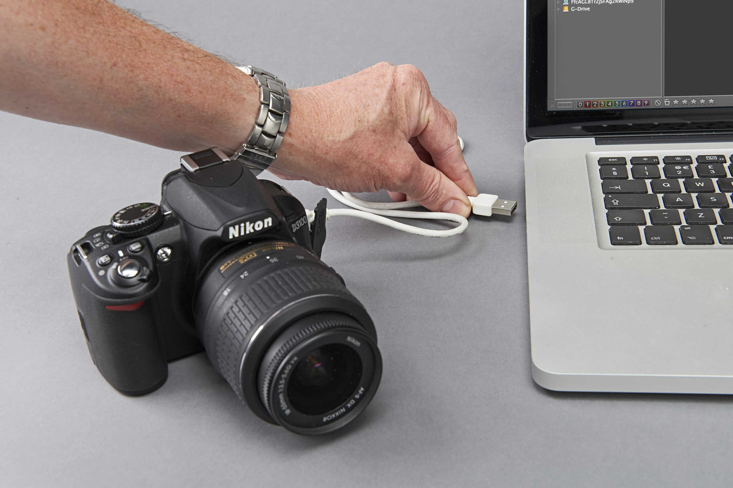 كاميرا Nikon D3100 متصلة بجهاز كمبيوتر محمول عبر كابل USB
