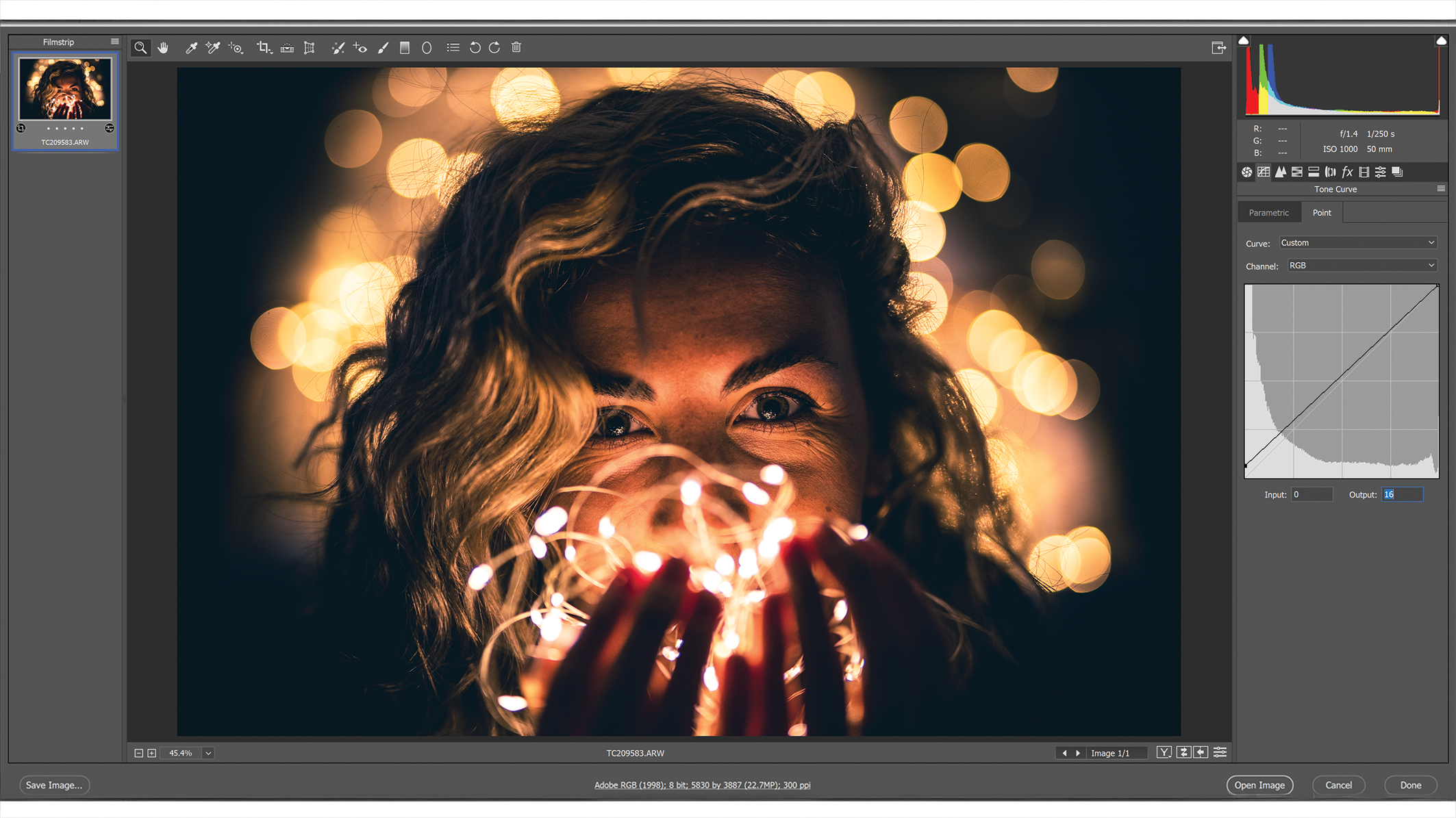 نافذة برنامج Photoshop مع قوائم التعديل، وصورة في المنتصف تظهر شخصًا بشعر مموج محاطًا بأضواء بوكيه ذهبية ناعمة تخلق جوًا دافئًا وحالمًا