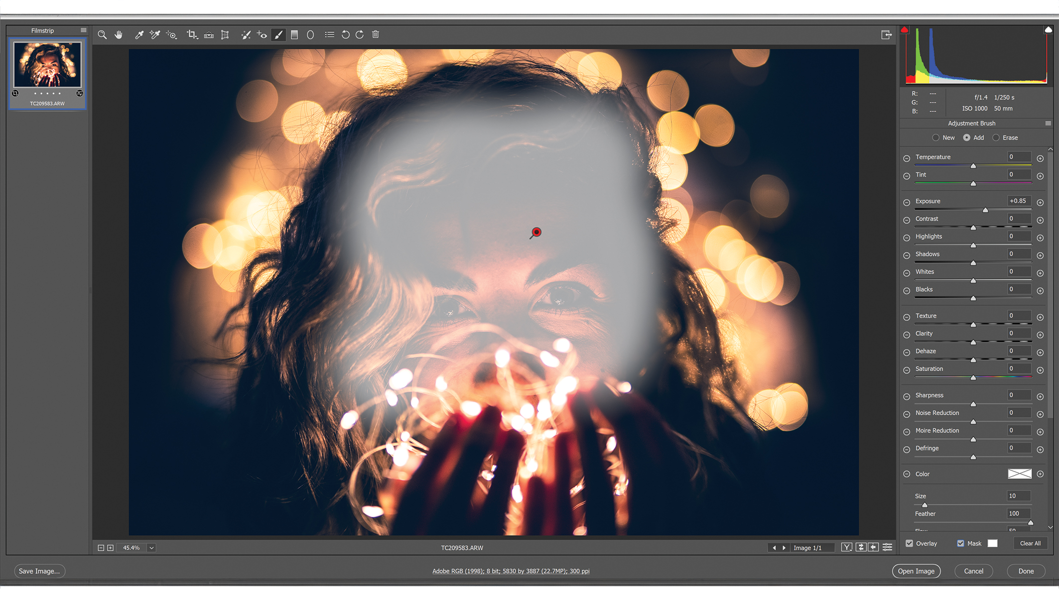 نافذة برنامج Photoshop مع قوائم التعديل، تظهر في المنتصف صورة لشخص ذي شعر مموج محاط بأضواء بوكيه ذهبية ناعمة تخلق أجواء دافئة وحالمة.
