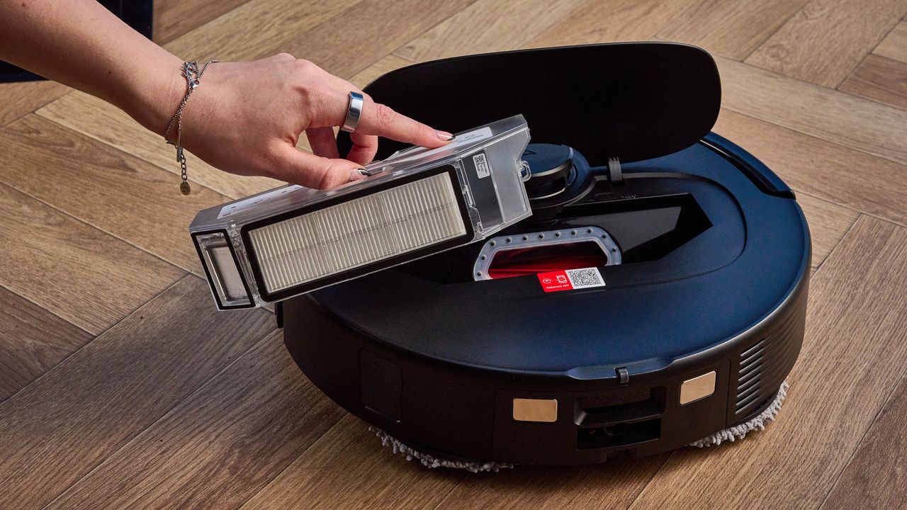 حاوية الغبار لمكنسة Roborock QV 35S مصورة أمام خلفية زرقاء