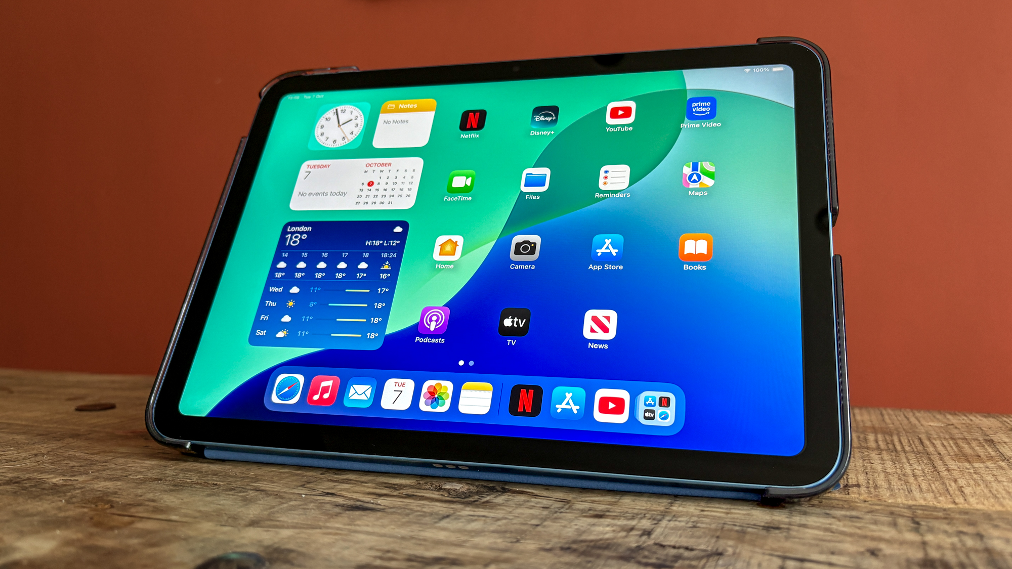 جهاز iPad 11 يعرض الشاشة الرئيسية وهو مستند على مكتب