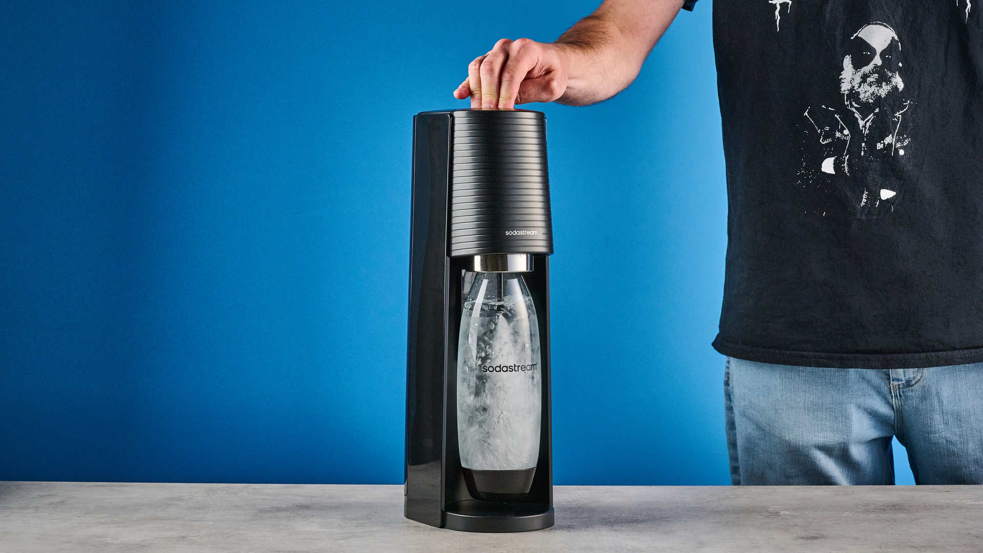 El dispositivo SodaStream se utiliza sobre un fondo azul.