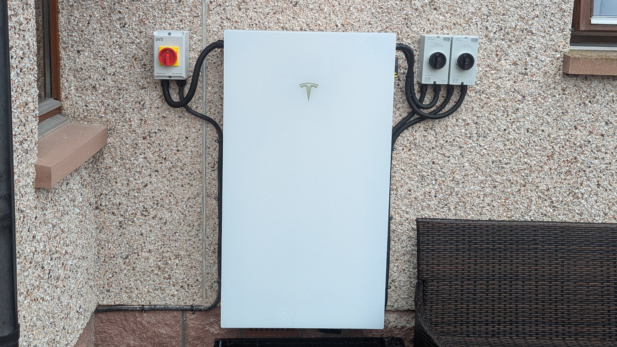 بطارية Tesla Powerwall مثبتة على الجدار الخارجي للمنزل