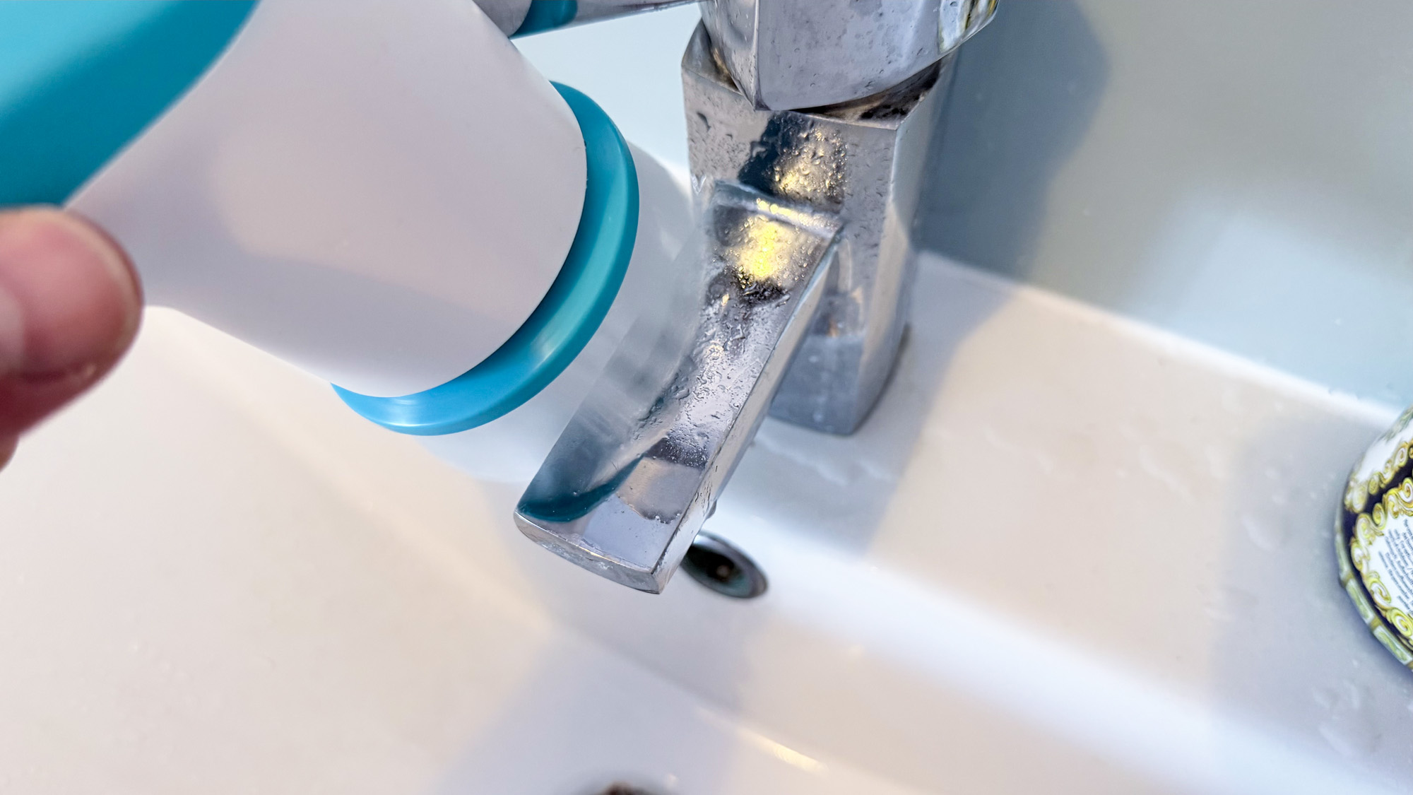 El dispositivo portátil Scrub Buddi se utiliza para limpiar grifos.