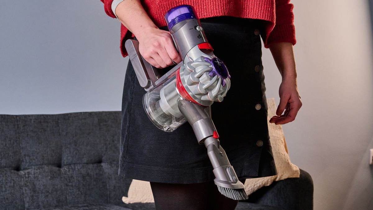 Eine Person, die einen Dyson Car+Boat Handstaubsauger hält