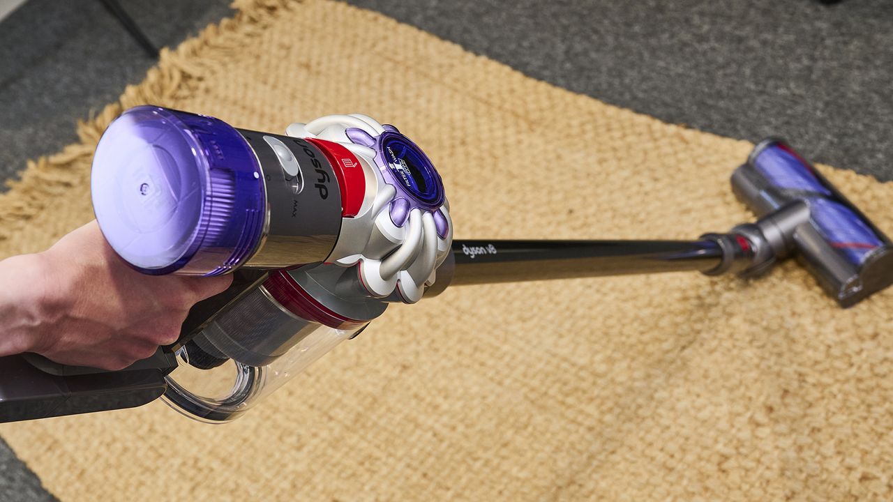 Eine Person, die einen Dyson V8 Staubsauger benutzt