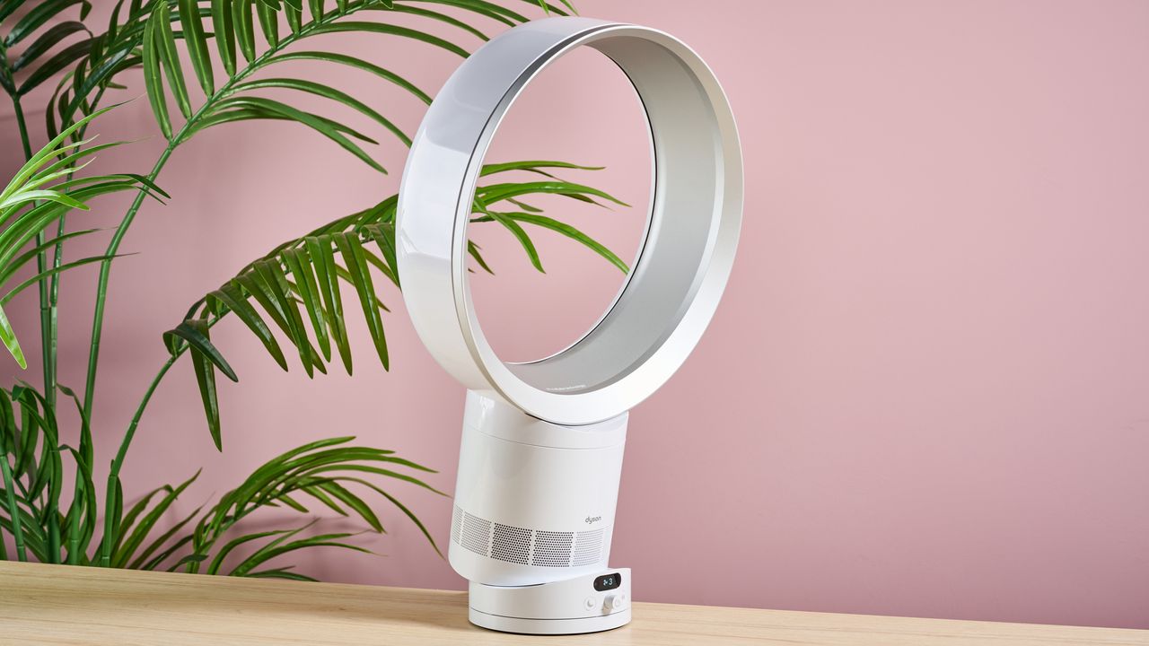 تظهر مروحة Dyson Cool CF1 مائلة للأسفل وهي موضوعة على سطح طاولة، أمام نبات أخضر مورق.