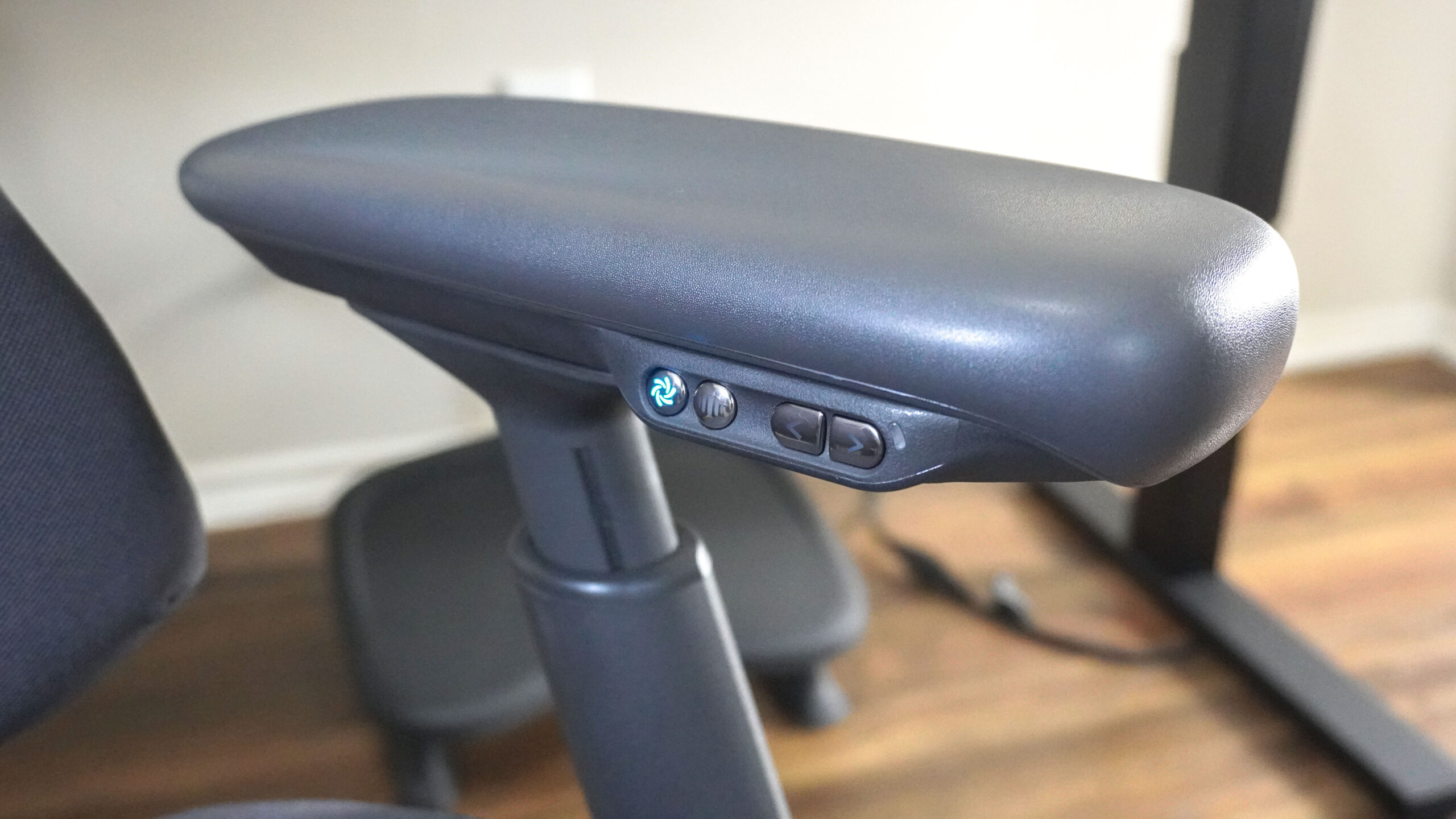 Un primo piano dei pulsanti del bracciolo sinistro della sedia LiberNovo Omni Pro.