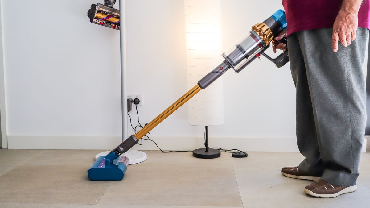 Eine Person, die einen Dyson V15s Detect Submarine Staubsauger hält