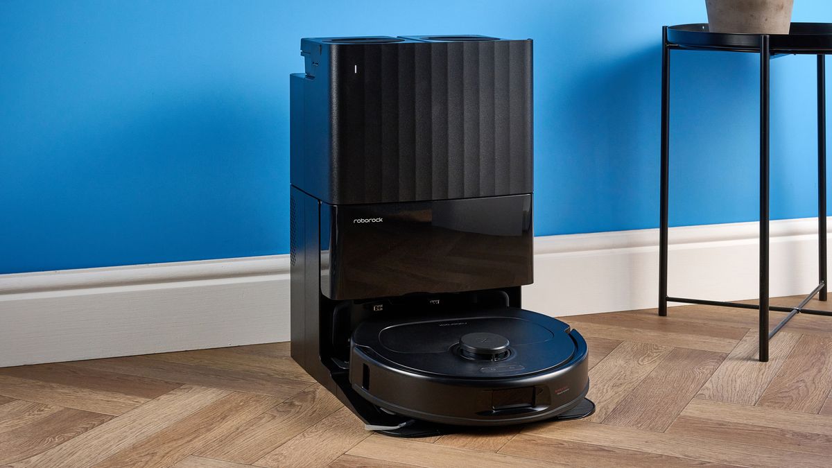 مكنسة Roborock QV 35S مع قاعدة الشحن مصورة أمام خلفية زرقاء