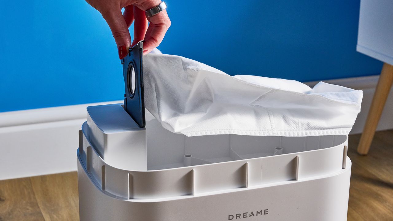 Dreame D10 Plus Gen 2 مصورة على أرضية خشبية أمام خلفية زرقاء
