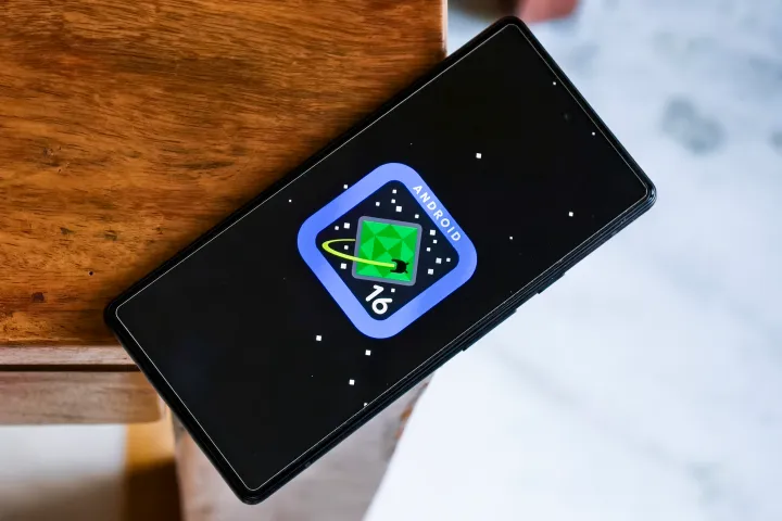Android 16 logo on Google Pixel 6a kept on the edge of a table.