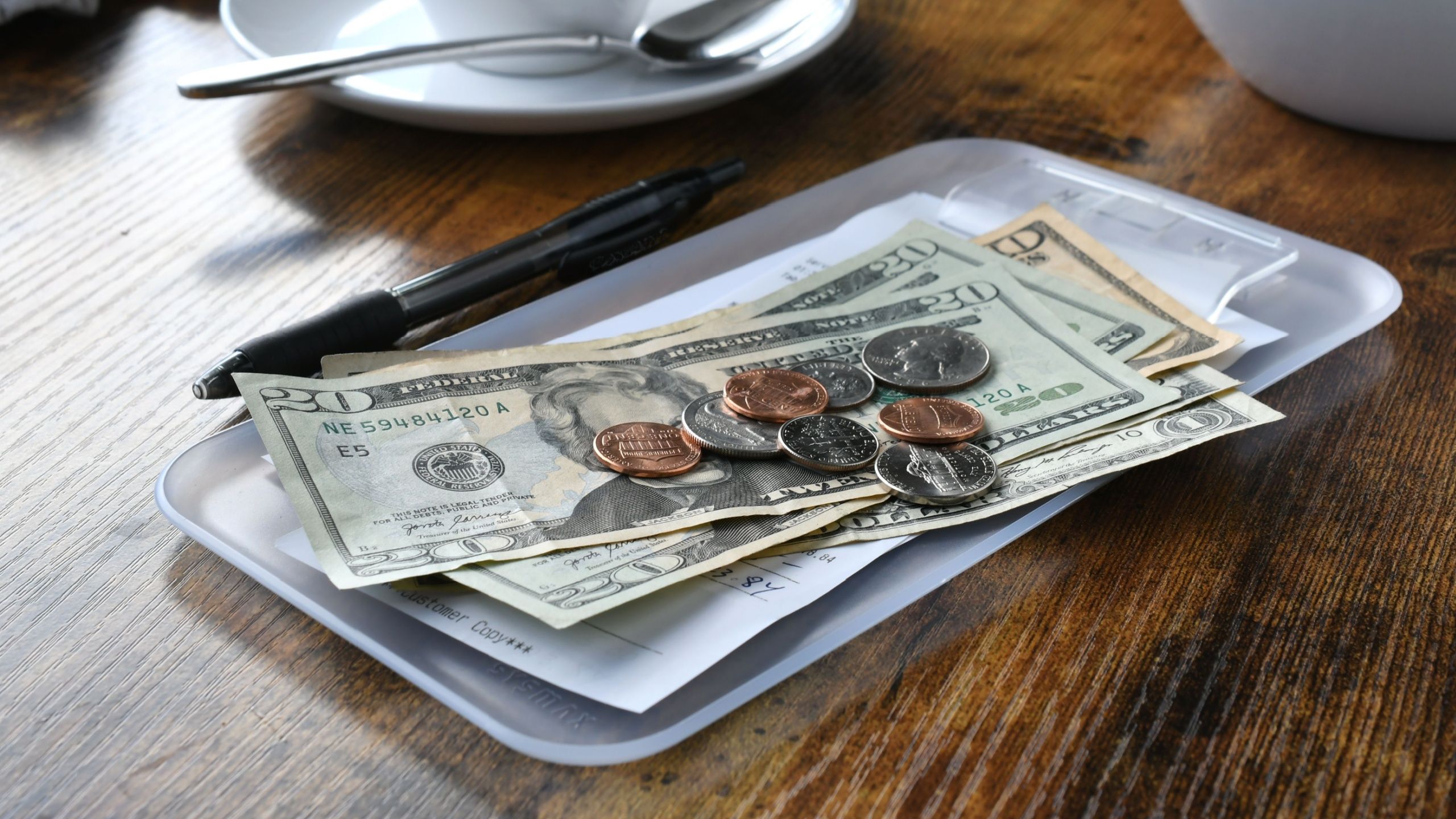 Dollars and coins on a restaurant check holder