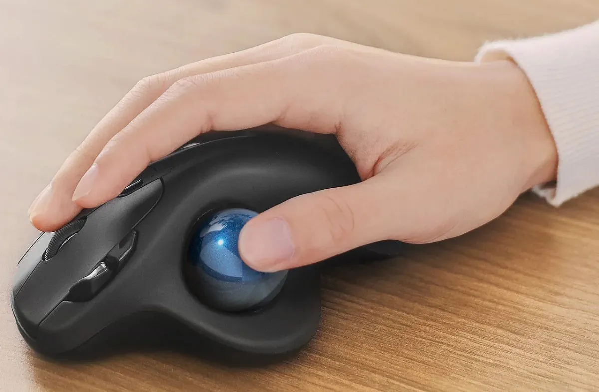 Hand using a thumb-operated trackball