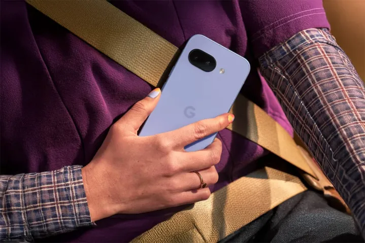 Person holds Pixel 9a in hand while sitting in a car.