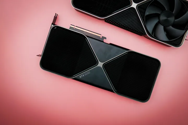 The RTX 5090 sitting on a pink background.