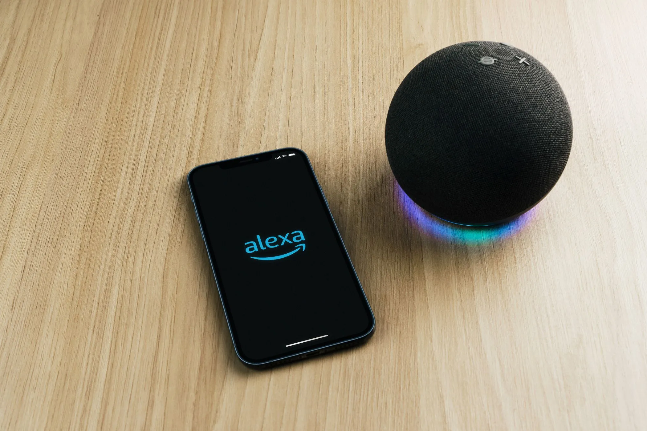 the alexa app on a smartphone on a table next to an echo speaker 