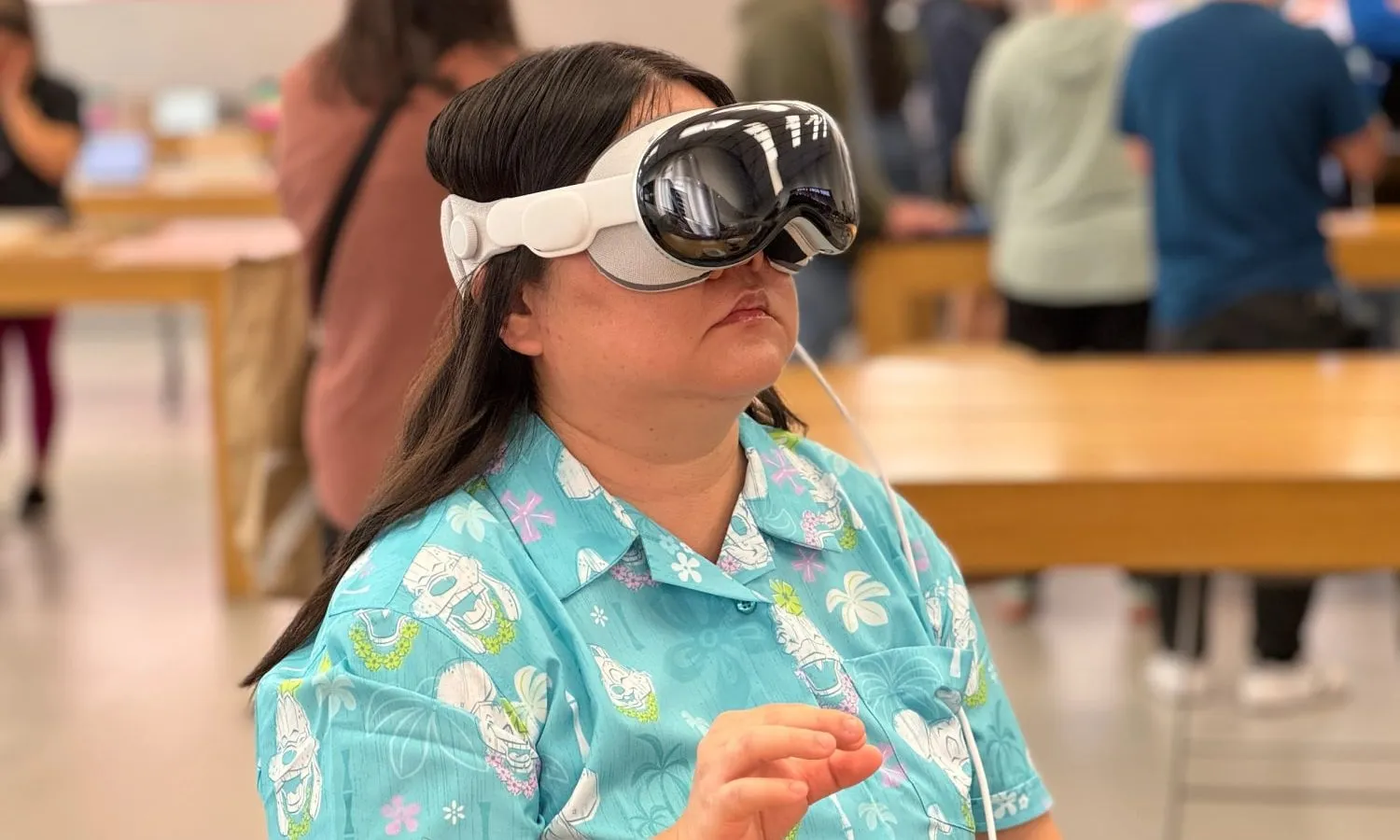 شخص يرتدي وحدة عرض Apple Vision Pro في متجر Apple.